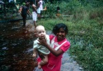 Girl with baby Angeline Ann Widmer, Bahá’í youth camp near Georgetown (12/75)