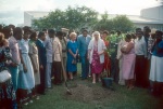 Rúhíyyih Khánum at tree planting ceremony, Lea Nys (blue dress) holding her purse, dedication ceremonies of the Anís Zunúzí Bahá'í School (10/82)