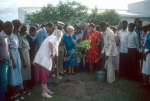 Rúhíyyih Khánum at tree planting ceremony, Lea Nys (blue dress) holding her purse, dedication ceremonies of the Anís Zunúzí Bahá'í School (10/82)