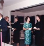 Joyce Dahl (green dress) talking with Velma Sherill at reception for Paul Haney, Wilmette, 4/61