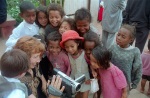 Emi showing the video camera to children at a wedding, December