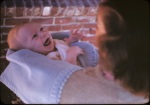 Joyce w baby Arthur swaddled in blanket in patio, 10/12/1942